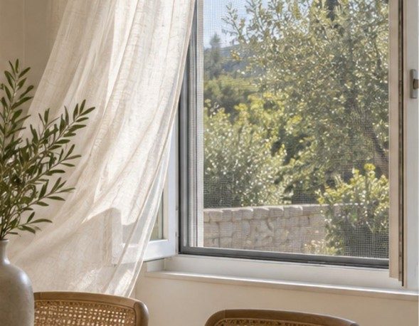 Ventana abierta con mosquitero y cortina movida por el viento